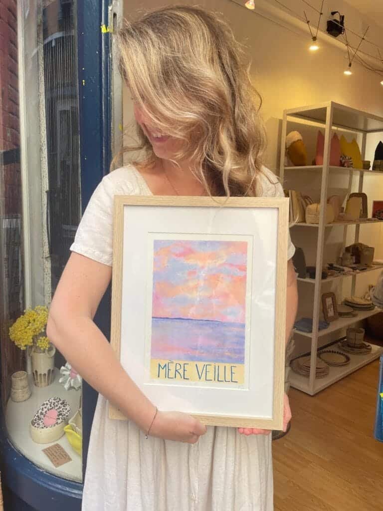 Marjorie Cia tenant une de ses Œuvres picturales